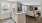 Spacious and well lit kitchen with wood flooring and stainless steel appliances