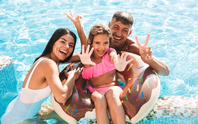 Family having fun in the swimming pool 